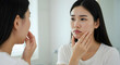 © Nur - Woman looking at her reflection concerned about acne skincare beauty treatment facial problems