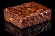 © Khatyjay - Rich, fudgy chocolate brownie on a reflective black surface, showcasing its texture and sheen