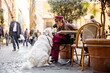 © rh2010 - A stylish woman enjoys coffee at an outdoor cafe in Rome while bonding with her large white dog. The image conveys European lifestyle travel and emotional pet connection