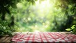 © elisa - Wooden table with red checkered tablecloth, lush green foliage background