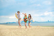 © Wanwajee - Dynamic beach moment: Friends jumping, smiling, and playing with inflatable rings. Shot reflects holiday joy, active travel lifestyle, and tropical escape.