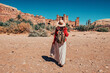 © EdNurg - Female tourist walking towards Ait Benhaddou, an ancient fortified city - ksar - in Morocco, on a sunny day