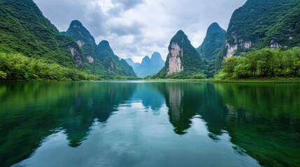 Poster - Serene landscape of karst mountains reflected in a tranquil jade-green lake, lush vegetation lines the shores under a cloudy sky. : Generative AI
