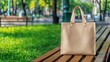 © Omias - Handstitched Concept, Handstitched Tote Bag Resting on Wooden Bench Surrounded by Lush Greenery in Bright Outdoor Setting