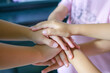 © cherdchai - Team Huddle A friendly family joins their hands as a sign of joint success Stack of hands, below and children in nature for unity, support and friendship, girls stacking hands together in teamwork