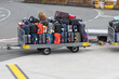 © Thomas - Colorful luggage stacked on airport baggage cart