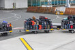 © Thomas - Colorful luggage stacked on airport baggage cart