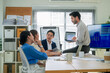 © whyframeshot - Colleagues having a meeting in office boardroom asian young businessman lead his team to discuss their projects  Businesswoman and businessman leading a meeting in office
