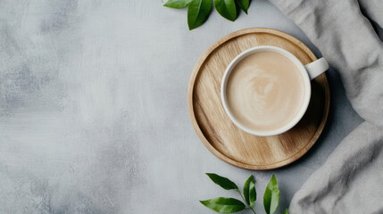 Poster - Aromatic coffee in a white mug rests on a wooden tray, accompanied by fresh green leaves and a soft grey fabric, creating a serene morning scene. : Generative AI