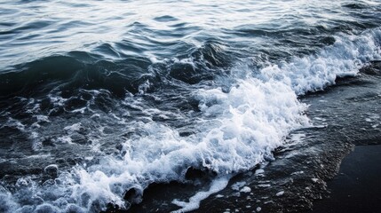 Aufkleber - Ocean wave breaking on a dark sandy beach, creating a beautiful contrast of white foam and deep blue water. The image evokes a sense of serenity and the power of nature. : Generative AI