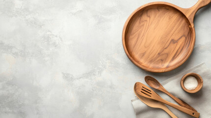 Poster - Overhead view of a rustic wooden serving platter, spoons, and a small bowl of salt on a light gray textured surface, perfect for culinary or food-related designs. : Generative AI