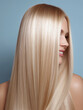 © southwind - Beautiful blonde woman showing shiny straight hair on blue background