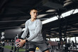 © Davidovici - Horizontal photo of fitness man model exercising with medicine ball at gym. Young strong guy doing workout using fitness ball. Strength training, discipline, and fitness lifestyle concept