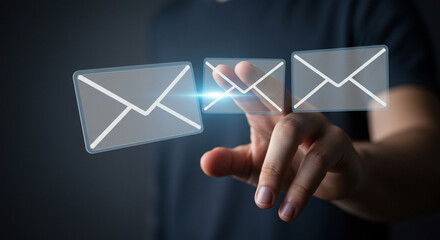 A person touching three email icons with a bright light between them on a dark background in a close up