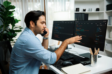 Smart IT developer manager calling to coworker solving problem in software coding system on pc screen, creating application program update latest version online website data at modern office. Surmise.