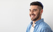 © Prostock-studio - Closeup headshot portrait of casual cheerful jewish guy in yarmulke standing at studio, looking and posing at camera with a smile isolated on white studio background, free copy space, panoramic banner