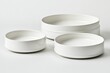 © Ikhwan - Three white ceramic bowls of varying sizes,  stacked in a studio setting.  Each bowl has a subtle raised ring around the middle and a flat base