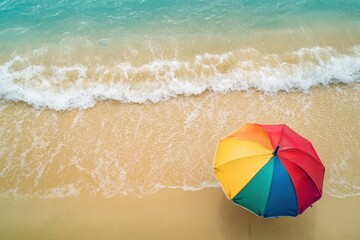 Wall Mural - Colorful umbrella rests on sandy beach while ocean waves gently splash in the background under a clear sky, Colorful umbrella on sandy beach by ocean