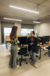 © Roman - Two Women Having a Discussion in a Modern Office Setting