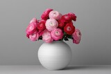 A vase of colorful ranunculus flowers