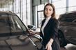 © anatoliycherkas - Saleswoman presenting new car to customer in dealership