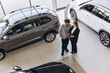 © anatoliycherkas - Salespeople using tablet, consulting about cars in a dealership