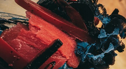 Poster - A close up of a red and blue food item with a black and blue background