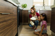 © AntonioDiaz - Mother and little girl waiting for cookies to be ready next to the oven
