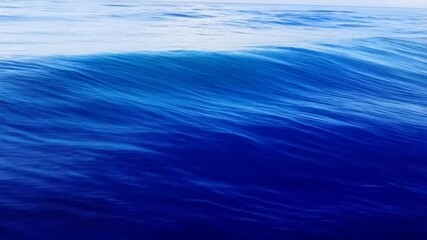 Wall Mural - A mesmerizing shot of a captivating blue ocean wave, capturing the sheer beauty and motion of water in its purest form.
