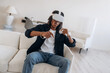 © standret - Conception of gaming. Black man in virtual reality glasses at home