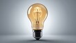 © yassine - Illuminating innovation, bright light bulb on a grey background symbolizing ideas, solutions and inspiration