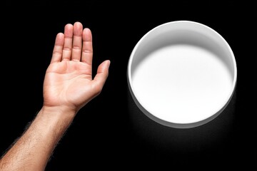 Leinwandbilder - Hand reaching towards a white bowl demonstrating a simple interaction in a minimalist setting