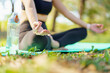 © DG PhotoStock - Asian woman practicing yoga and meditation under a big tree in the park during a peaceful morning.
