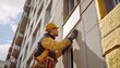 © habibah - Exterior building worker installing a sign on a high rise.