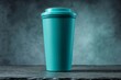 © MrHamster - Teal reusable beverage container on dark surface.