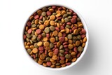 A full, colorful bowl of dry dog food is seen from an overhead, close-up perspective on white.