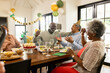 © WavebreakMediaMicro - Celebrating birthday with cake, family laughing and enjoying decorations together