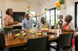 © wavebreak3 - Celebrating birthday, family gathering at home, sharing cake and conversation at table