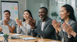 © Andres Mejia - Diverse business team clapping celebrating success in modern office