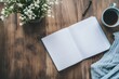 © black - Flatlay of open notebook, coffee, flowers, and sweater on wood