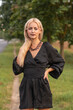 © shymar27 - Portrait of a young beautiful blonde girl in a dark dress in a city dress in the summer.