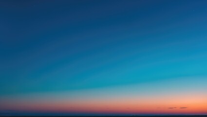 Wall Mural - Beautiful natural landscape with a colorful, cloudless sky transitioning from blue to orange at sunrise