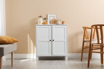 Poster - Dresser with stylish decor near beige wall indoors
