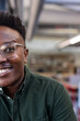 © WavebreakMediaMicro - Smiling man in glasses wearing green shirt at modern office workspace