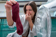 © ADDICTIVE STOCK - Gen-Z Girl Holding Smelly Sock with Disgusted Expression at Washer