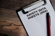 © syahrir - Concept of Safety Data Sheets - SDS write on paperwork isolated on Wooden Table.
