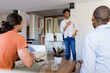 © WavebreakMediaMicro - At home, man standing and gesturing while friends listen during conversation