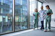 © zinkevych - Group of young doctors in lab coats walking in the clinic corridor and talking