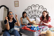 © WavebreakMediaMicro - Packing suitcase and laughing, three young women enjoy sunny afternoon at home