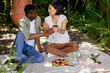 © WavebreakMediaMicro - Sharing conversation and holding smartphone, couple having picnic outdoors together